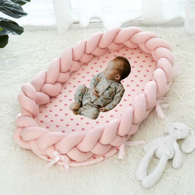 Bébé dort dans son couffin bébé rose tressé doux.