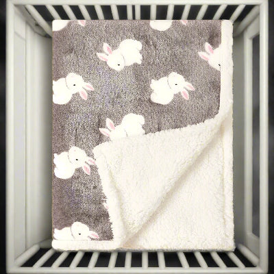 Couverture bebe lapin douce déposé sur le berceau de bébé.