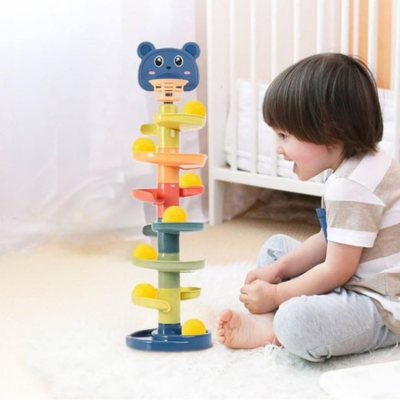 Petit garçon assis explore son jouet bebe eveil tour à balles 5 étages.