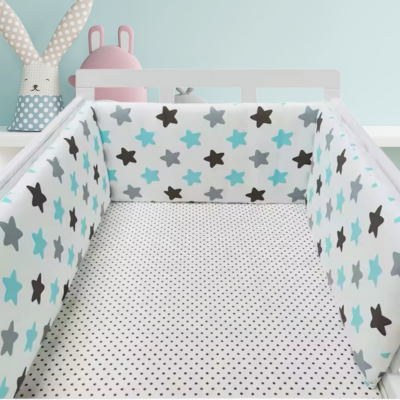 Tour de lit bebe étoile installé dans un lit à barreau vue de près.