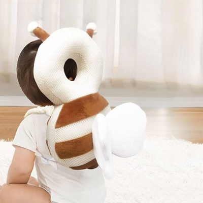 Bébé assis portant le coussin de protection anti-choc abeille tourné sur le dos, zoom sur le coussin.