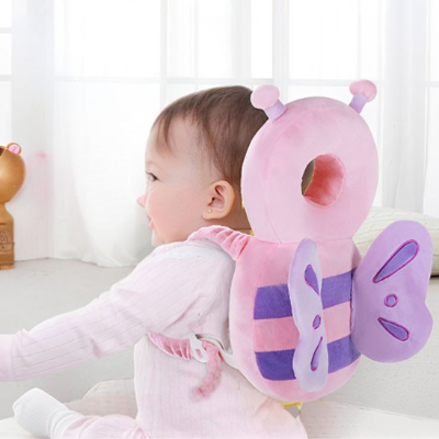 Petite fille portant le coussin de protection anti-choc headsafety rose papillon.