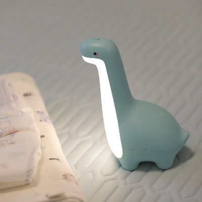 Vue de côté de près sur la veilleuse bébé dinosaure vert.