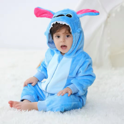 Petit garçon assis sur le tapis portant sa barboteuse câlin mignon dragon bleu.