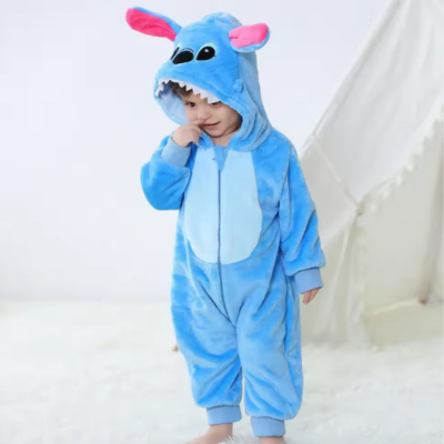 Petit garçon debout, rit, portant sa barboteuse câlin mignon dragon bleu