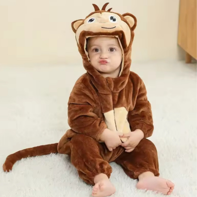 Un petit enfant assis sur le tapis portant sa barboteuse câlin mignon singe.