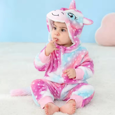 Bébé portant sa barboteuse câline mignonne licorne, assise sur le plancher.