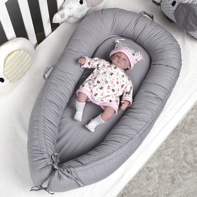 Poupée bébé couché dans le cocon bebe nid apaisant.