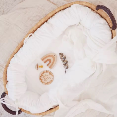 Cocon bebe placé dans un couffin en maille.