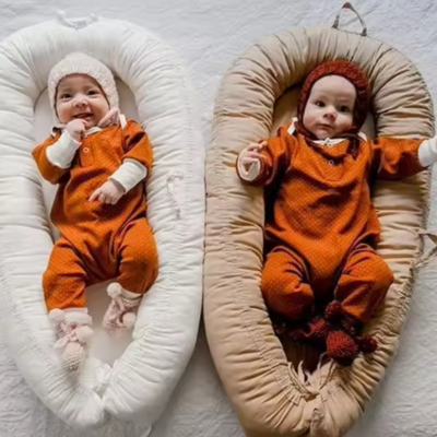 Deux bébés couchés dans leur cocon bebe nuit apaisant confortablement.