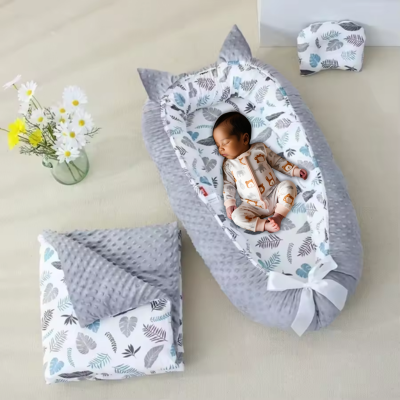 Bébé dort dans son couffin bébé veloute gris feuille.