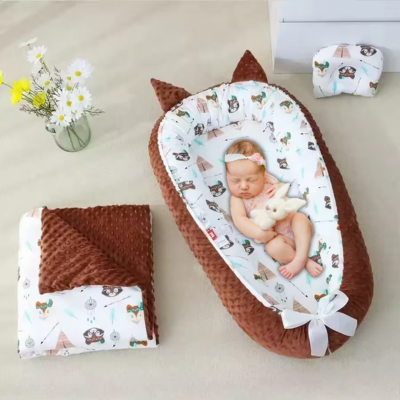 Bébé dort dans son couffin bébé velouté marron.