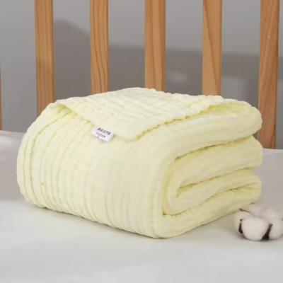 Couverture bébé en coton jaune plié, zoom sur elle.