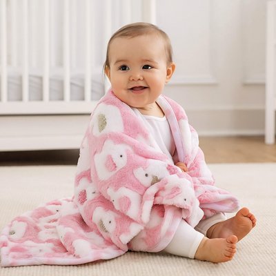 Bébé fille assise se couvrant de la couverture bebe éléphant ultra-douce sur son dos. 