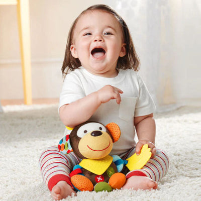 Petite fille éclate de rire en jouant avec son doudou bebe, Cozyrattle.