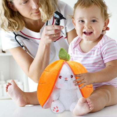 Bébé se fait réconforter par son doudou lapin enchanteur pendant que le médecin l'évalue.