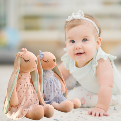 Petite fille joue avec son set de doudou lapin Lili et compagnon.