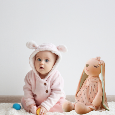 Bébé joue dans sa chambre en compagnie de son doudou lapin Lili.