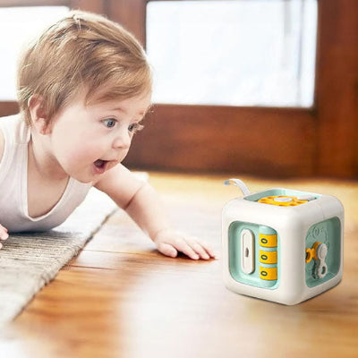 Bébé émerveillé de voir son jouet bebe cube interactif Montessori 6-en-1.