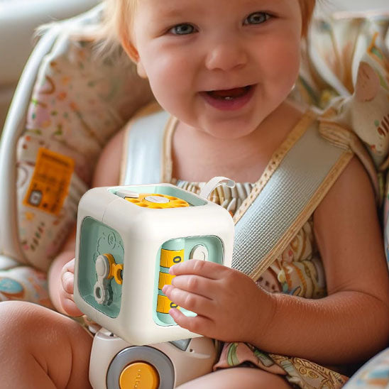 Zoom sur le visage de la  petite fille souriante jouant avec son jouet bebe cube interactif Montessori 6-en-1.