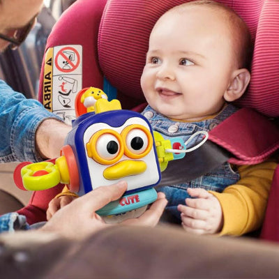Bébé heureux de recevoir son jouet bebe eveil, pendant qu'il est assis dans son siège de voiture.