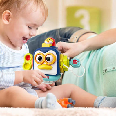Petit enfant heureux d'interagir avec son jouet bebe eveil cube 10 en 1.