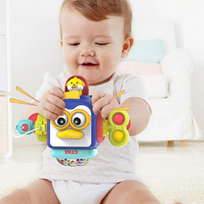 Petit garçon content de manipuler différentes parties de son jouet bebe eveil cube 10 en 1.