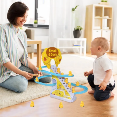 Maman et petit garçon en rires voyant les petits canards monter et descendre sur la piste du jouet bebe piste musicale. 