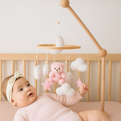 bébé stimuler par les sons et musique apaisante émis par le mobile bebe ourson rose.