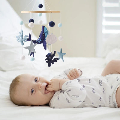 bébé joue et rit éclaté avec le mobile musique bebe dans son lit.