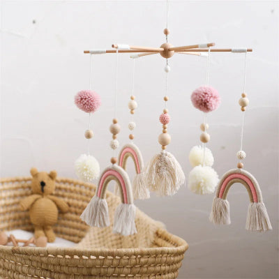 Vue de près, sur le mobile pour lit bebe arc-en-ciel installé proche du couffin bébé.