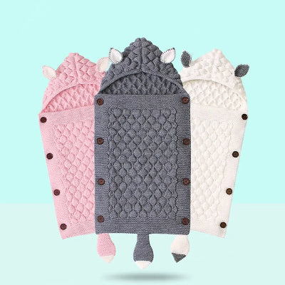 Les trois couleurs du nid d'ange bebe gris, blanc et rose, mises en avant sur un fond bleu ciel.