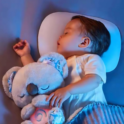 Bébé dort paisiblement dans son lit collé à sa peluche koala grise.