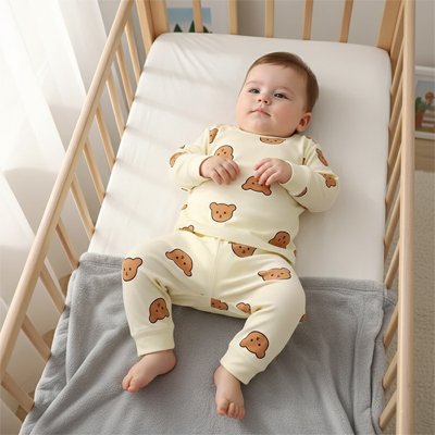 Bébé est couché dans son berceau confortablement dans son pyjama bebe beige 100% coton doux.
