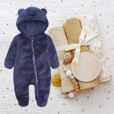 Pyjama bebe polaire bleu placé sur un fond de couverture. 