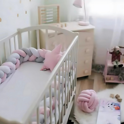Tour de lit bebe blanc, rose et gris installé dans le lit à barreaux, vue de loin. 