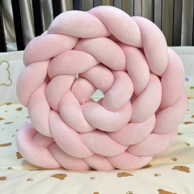 Tour de lit bebe rose roulé sur lui-même.