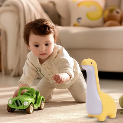 Bébé joue seul en présence de son compagnonne veilleuse bébé dinosaure jaune.