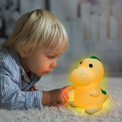 Petit garçon touche délicatement la veilleuse bébé Led Dinosaure.