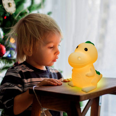 Un petit garçon émerveillé par la veilleuse bébé Led Dinosaure.