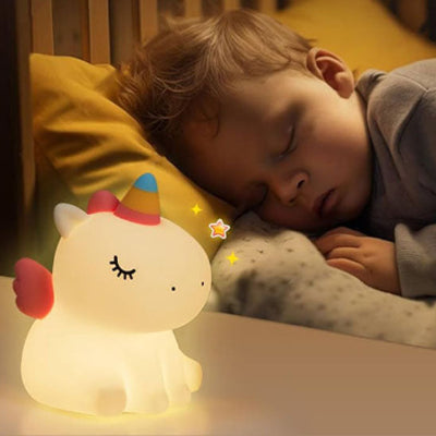 Veilleuse bébé Licorne posée sur la table de nuit pendant que bébé dort paisiblement à côté.